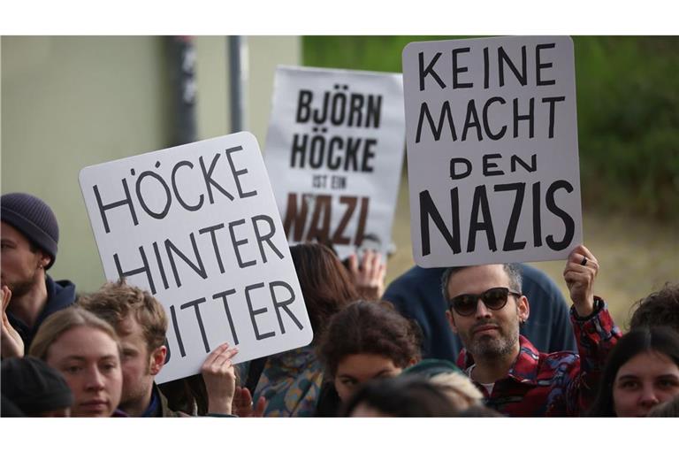 Björn Höcke, Vorsitzender der Thüringer AfD, muss sich vor dem Landgericht Halle verantworten. Demonstranten stehen am Justizzentrum und halten Plakate.