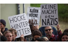 Björn Höcke, Vorsitzender der Thüringer AfD, muss sich vor dem Landgericht Halle verantworten. Demonstranten stehen am Justizzentrum und halten Plakate.