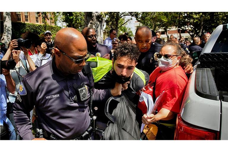 Ein Demonstrant der University of Southern California wird während einer pro-palästinensischen Besetzung des Alumni-Parks in Los Angeles von Beamten des USC Department of Public Safety festgehalten.