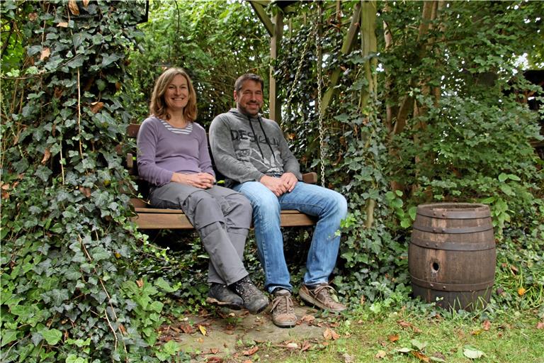 Jutta und Achim Schopf sitzen auf einer Schaukel in ihrem Garten. In dem Fass rechts hatten Hornissen einst ihr Nest. Fotos: Melanie Maier