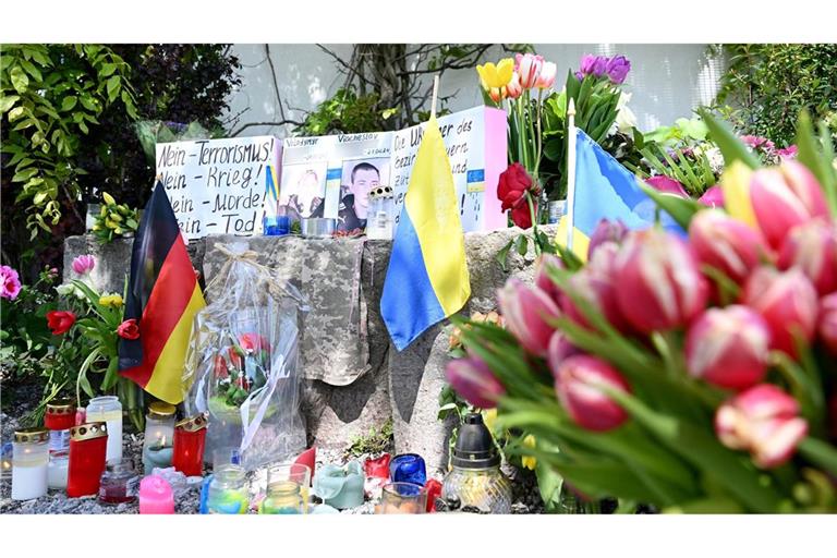 Neben dem Einkaufszentrums an dem die zwei Männer aus der Ukraine getötet worden sind, haben Menschen Blumen und Plakate niedergelegt.