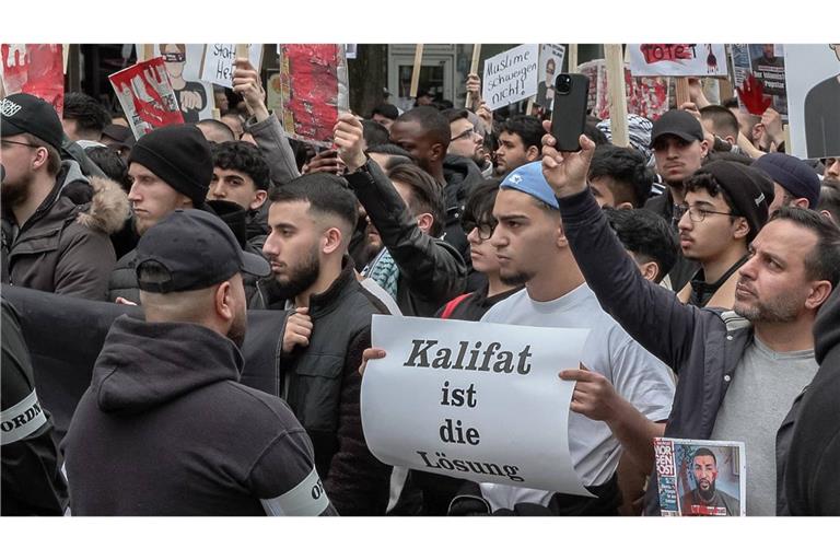 Teilnehmer einer Islamisten-Demo halten am 27. April in Hamburg ein Plakat mit der Aufschrift „Kalifat ist die Lösung“ in die Höhe.